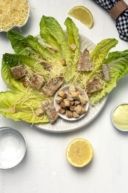 Salada caesar caseira com romanine, queijo, croutons, frango, limão e molho.