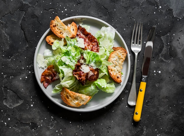 Salada Caesar com bacon em uma vista superior de fundo escuro Deliciosas tapas de aperitivo de brunch