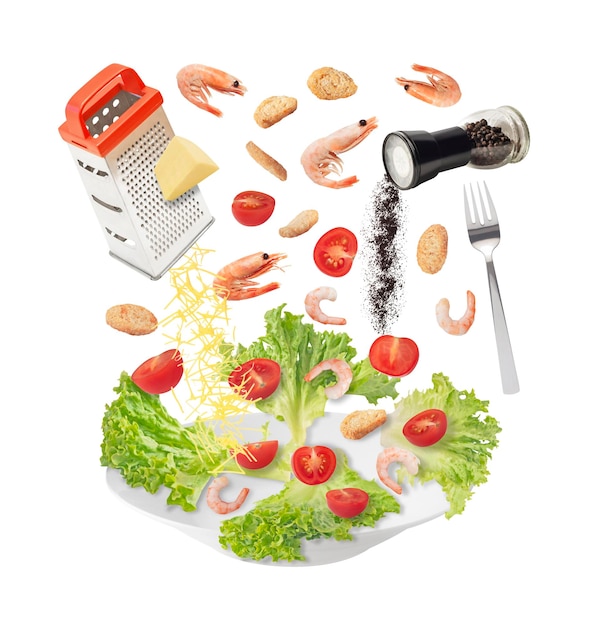 Salada Caesar com camarões de queijo ralado alface e outros ingredientes caindo no prato