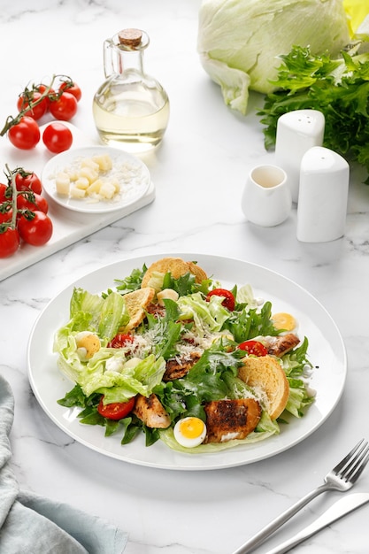 Salada caesar com croutons de tomate de carne de frango assado e queijo parmesão em chapa branca