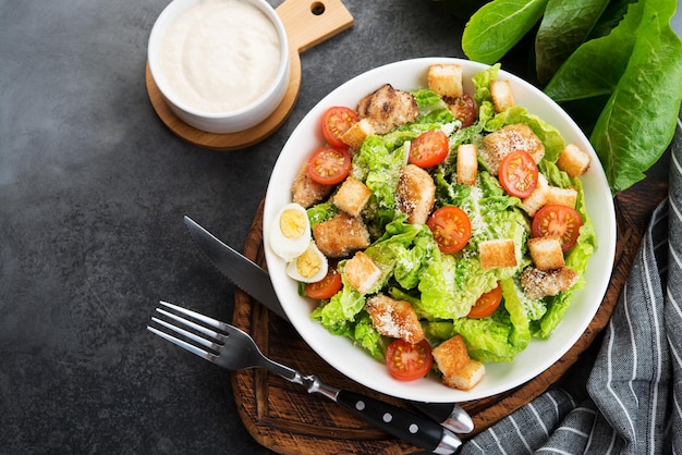 Salada Caesar com filé de frango, tomate cereja e croutons, comida italiana tradicional, vista de cima, copie espaço