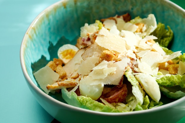 Salada Caesar com frango, croutons e parmesão. Fundos brilhantes. Sombras duras, foco seletivo.