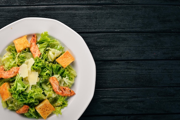 Salada Caesar com frango e legumes frescos Em um fundo de madeira Vista superior Copiar espaço