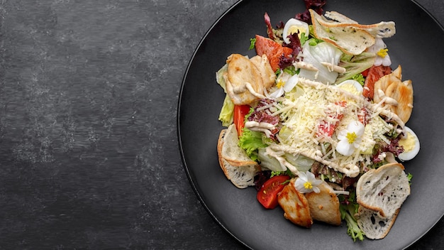 Salada Caesar com frango em um prato preto