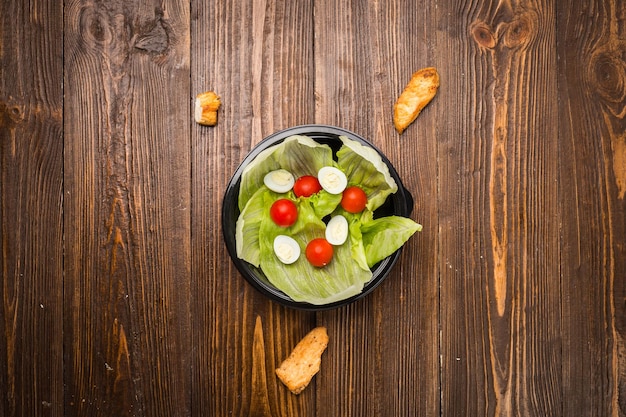 Salada Caesar com frango tomate cereja e ovos de codorna em um prato