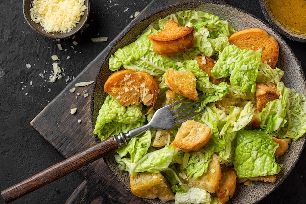 Salada Caesar com queijo parmesão crotons crocante e molho para almoço ou jantar saboroso em um prato com garfo