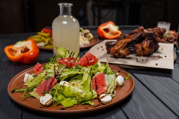 Salada caesar com toranja com costela de porco grelhada, legumes em conserva e aguardente