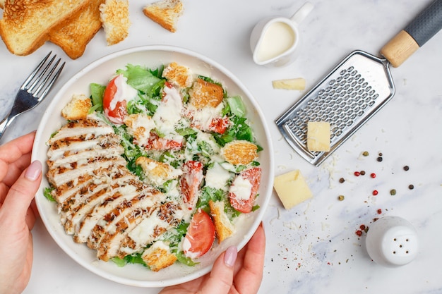 Salada Caesar de frango grelhado saudável com alface, queijo, tomate, croutons e molho gourmet