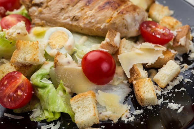 Salada Caesar de frango grelhado saudável com croutons de queijo e tomate cereja