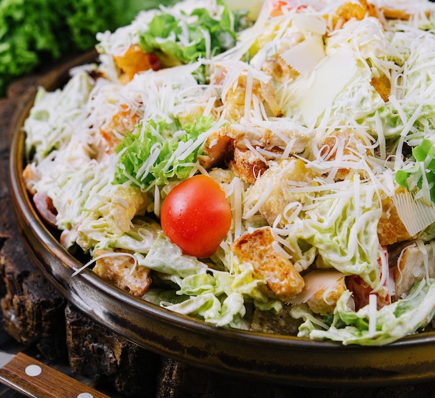 Salada Caesar fresca em uma mesa de cozinha de madeira