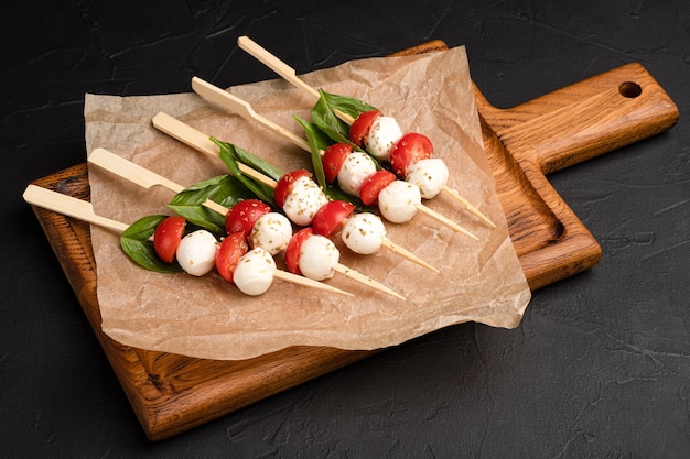 Salada caprese caprese como um lanche em um fundo preto