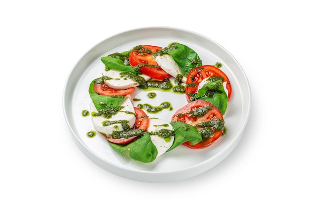 Salada caprese com mussarela, tomate, manjericão e vinagre balsâmico em um prato em um fundo branco isolado. Vista superior, copie o espaço.