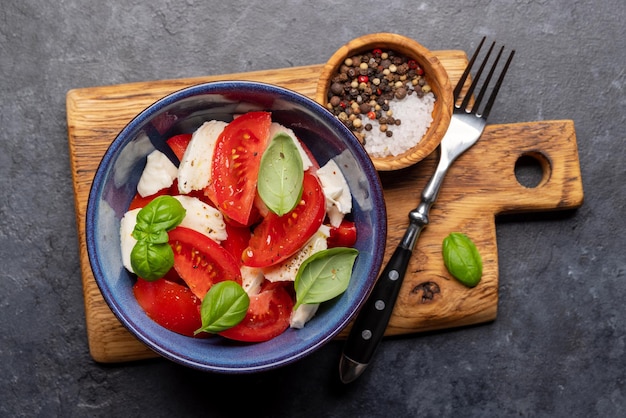 Salada Caprese com tomates maduros, mussarela e manjericão