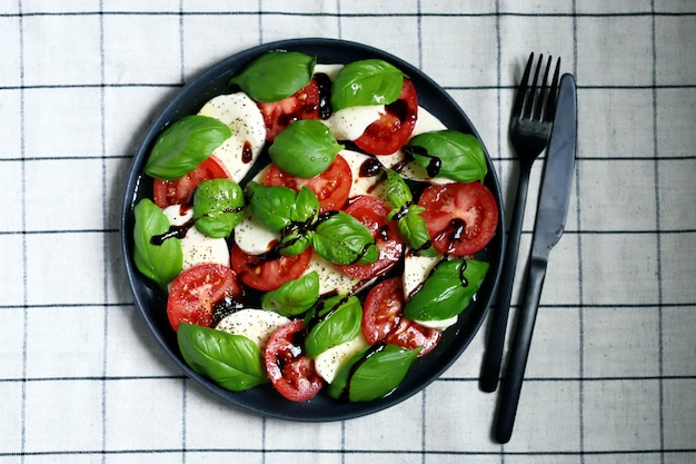 Salada caprese de assinatura italiana em um prato preto