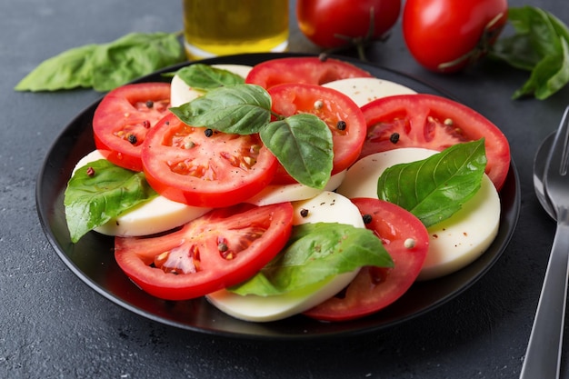 Foto salada caprese feita de tomates frescos fatiados, queijo mussarela e manjericão