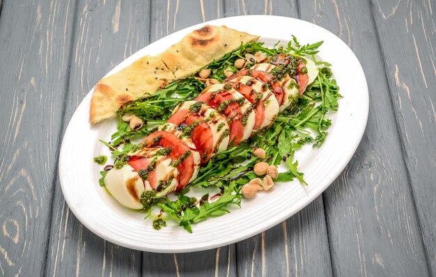 Foto salada caprese italiana com molho pesto e manjericão