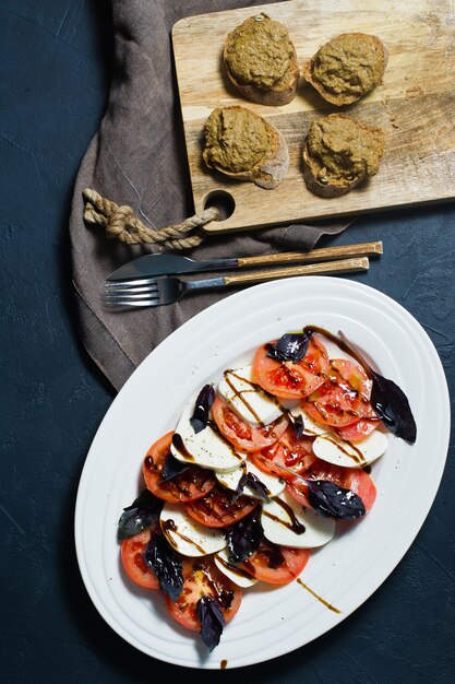 Salada Caprese italiana. Ingredientes mozzarella, tomate, manjericão, sal, pimenta, balsâmico.