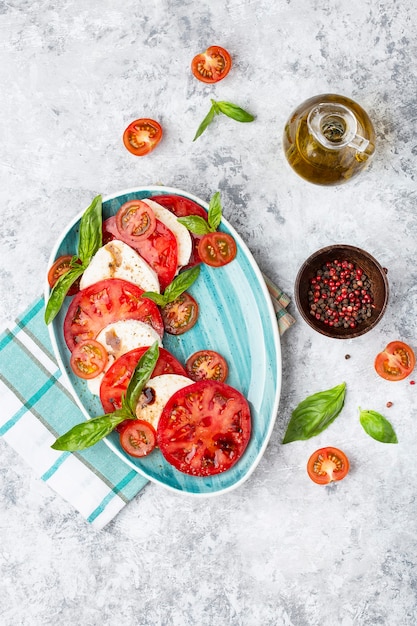 Salada caprese italiana tradicional com tomate fatiado, queijo mussarela, manjericão, azeite