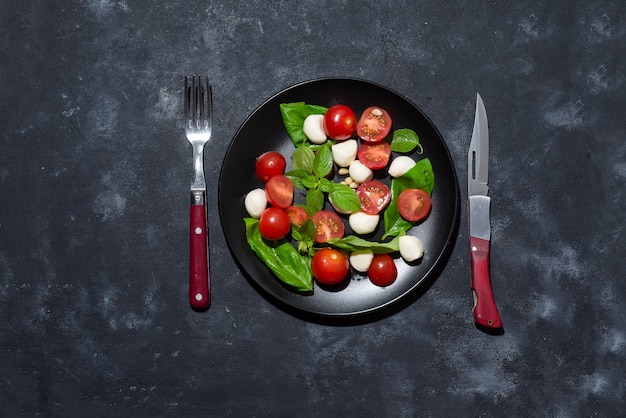 Salada caprese italiano fresco com mussarela e tomate na chapa preta