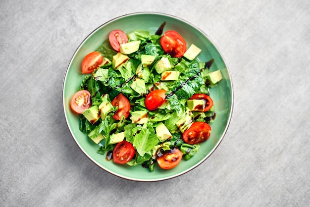 Salada com abacate e tomate cereja no processo de cozimento na cozinha