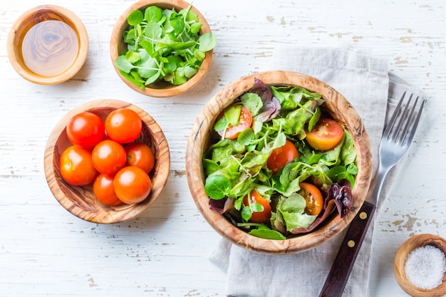 salada com alface e tomate em uma tigela de madeira