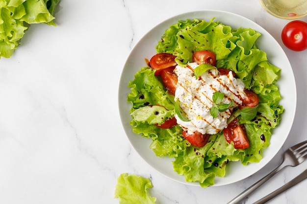 Salada com alface verde de queijo stracciatella deixa tomate e molho Dieta cetogênica saudável e desintoxicante