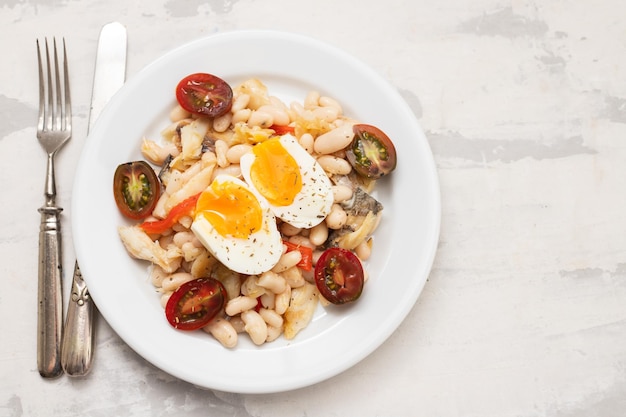 Salada com bacalhau frito e feijão branco no prato