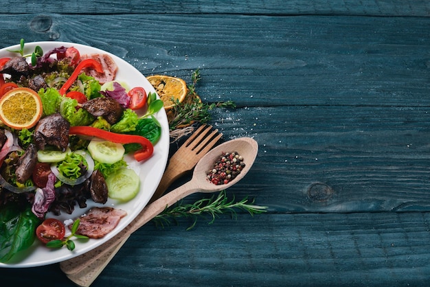 Salada com bacon e fígado de frango em uma superfície de madeira vista superior espaço livre para o seu texto