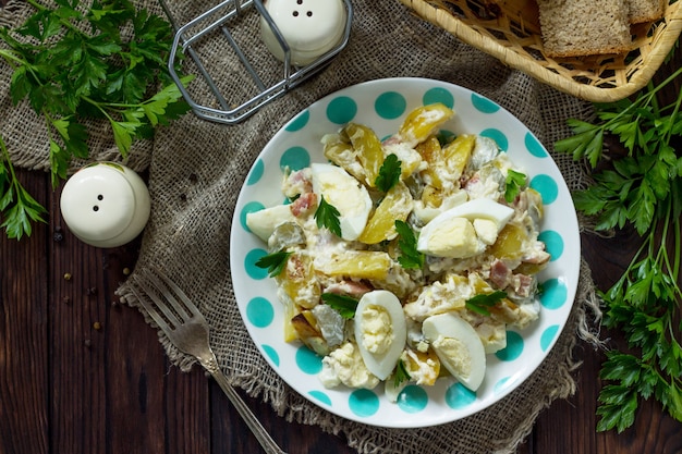 salada com batata assada pepino em conserva, ovo e peru defumado em mesa rústica