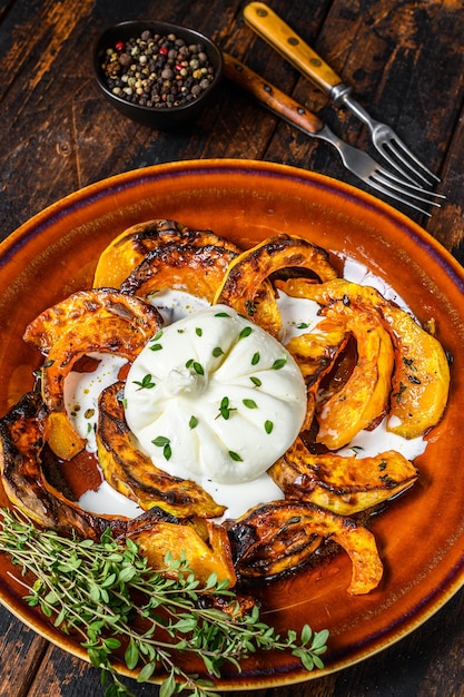 Salada com burrata de queijo e abóbora assada em um prato.