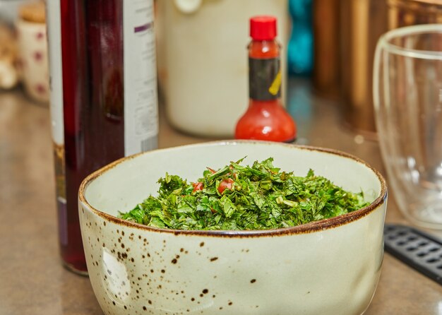 Salada com cebolinha, tomate e manjericão misturado em uma tigela funda.