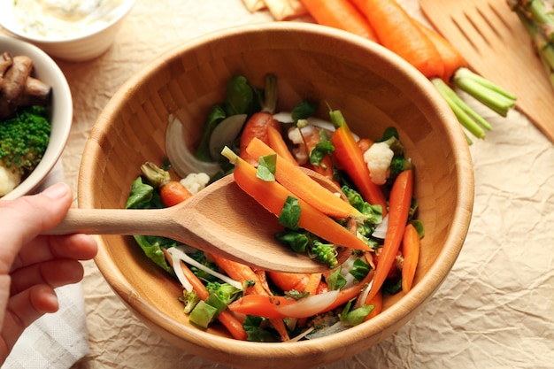 Salada com cenoura em uma tigela de madeira closeup