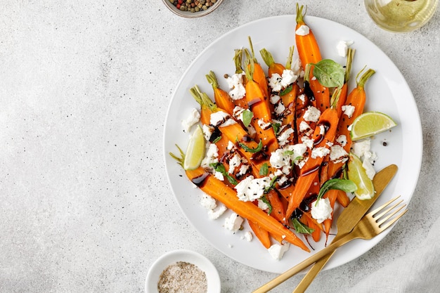 Salada com cenouras assadas assadas queijo feta ervas manjericão na chapa branca Dieta de comida vegana saudável