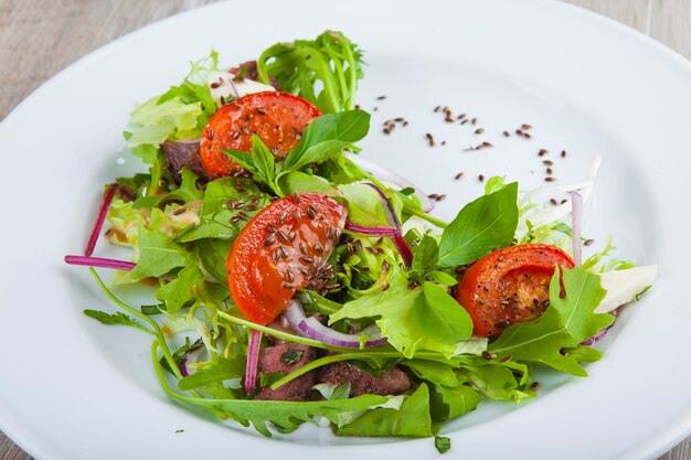 salada com ervas e tomate em um prato