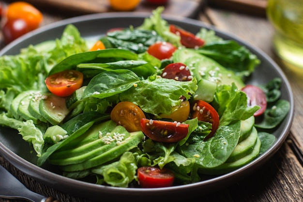 Salada com espinafre abacate tomate em um prato Salada vegetariana