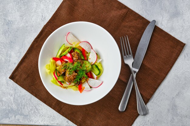 Salada com fígado bovino perto de rabanete e pepino