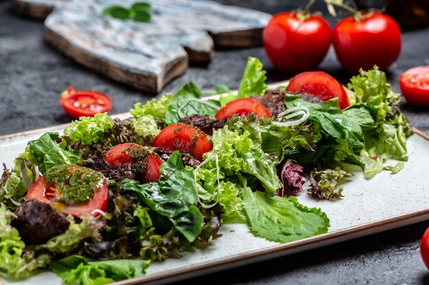 Salada com fígado de frango. Salada de legumes fresca. Salada de carne com fígado, salada de folhas, queijo, tomate no prato. Menu de dieta. Vista do topo