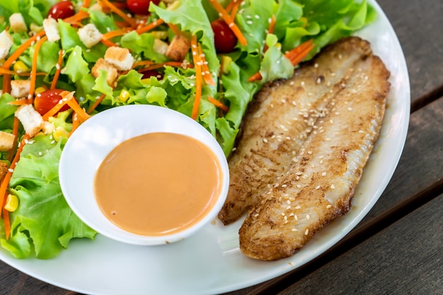 salada com filé de peixe frito