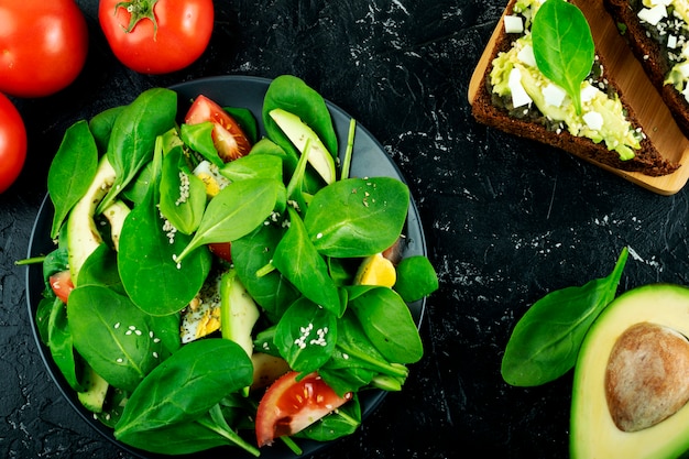 Salada com folhas de espinafre abacate e tomate. Nutrição adequada, demanda saudável por vida.
