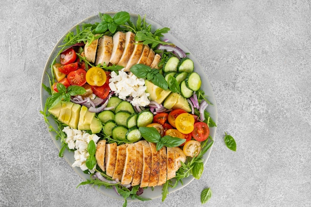 Foto salada com frango assado, abacate, cereja, tomate, pepino, rúcula e queijo feta