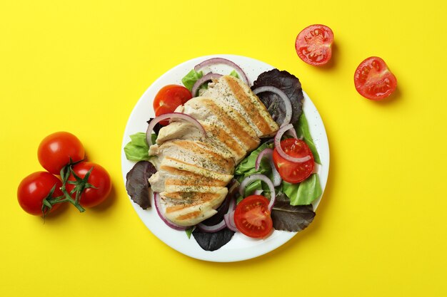 Salada com frango grelhado em fundo amarelo