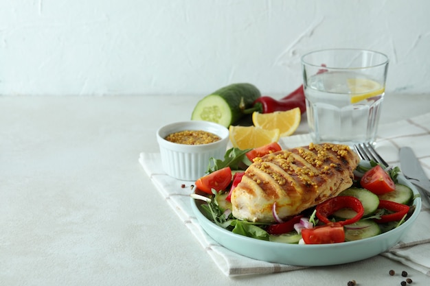 Salada com frango grelhado na mesa texturizada branca