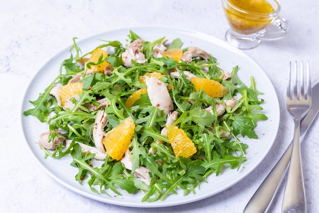 Salada com frango, laranja e rúcula. Molho com azeite e mostarda de grãos. Fechar-se.