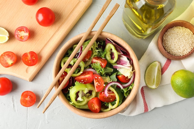 Salada com gergelim e acessórios de cozinha em cinza