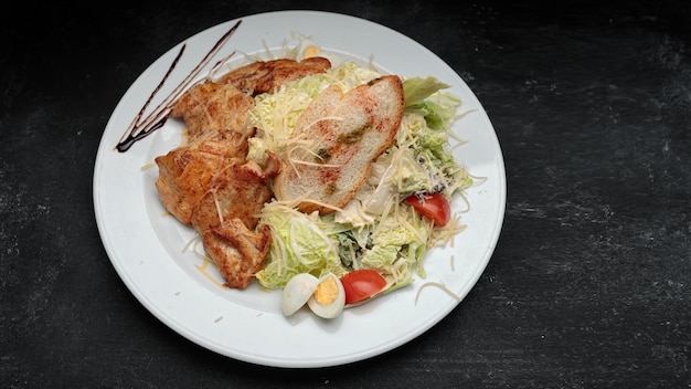 Salada com ovos de filé de frango em um fundo preto com espaço para texto