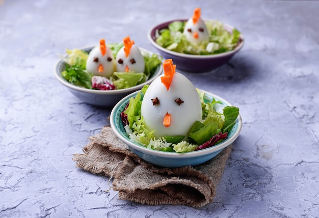 Salada com ovos em forma de galinhas. Comida festiva.