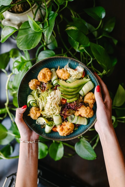 Foto salada com peixe frito abacate tomates pepinos e ervas