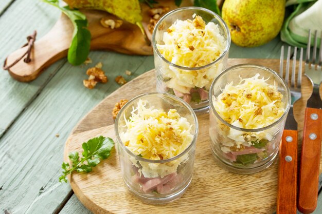 Salada com Pêra Presunto Ovo Nozes Frutas e Rúcula em mesa de madeira rústica