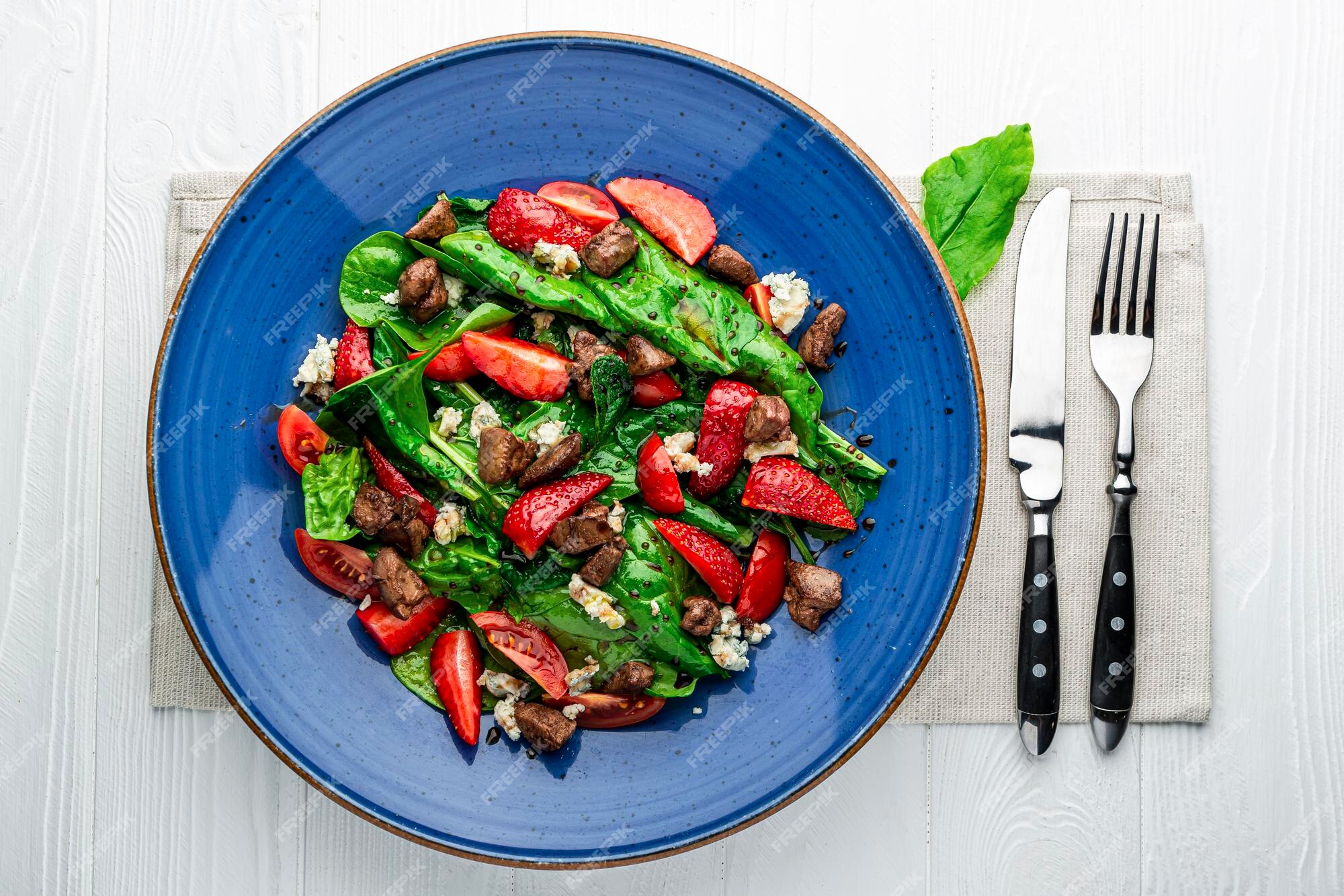 pedaços de fígado frito com cebola, folhas frescas de saladas