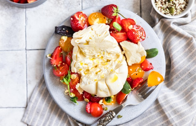 Salada com queijo burrata tomate cereja e morango com microgreen e azeite Keto diet